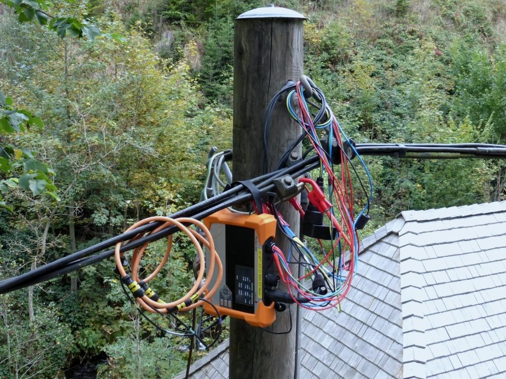 Netzanalysator am Holzmast einer Freileitung, angeschlossen mit Strom- und Spannungsabgriffen